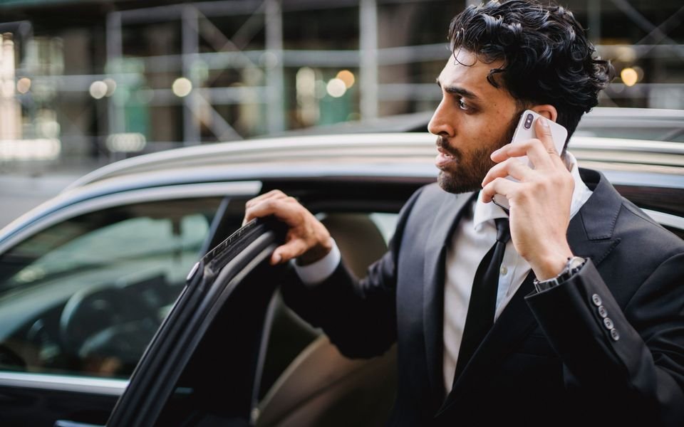 Client professionnel au téléphone montant dans un VTC