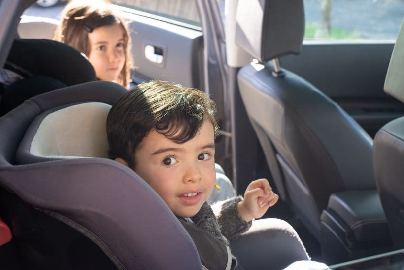 Enfant installé dans un siège auto adapté