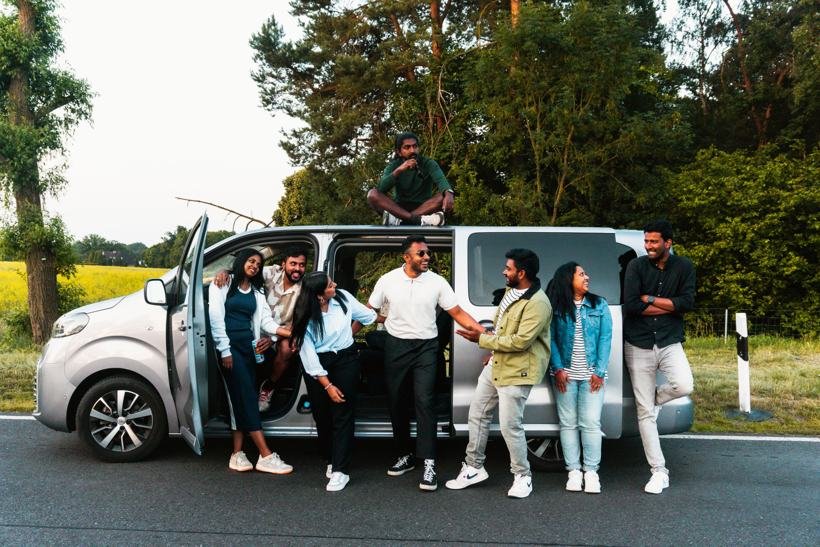 Groupe d'amis devant un van 8 places